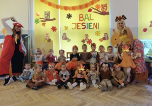 Zdjęcie grupowe dzieci z grupy 1 na tle jesiennej dekoracji