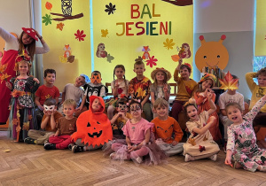Zdjęcie grupowe dzieci z grupy 5 na tle jesiennej dekoracji
