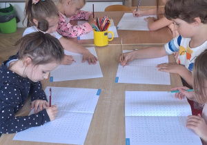 Dzieci z grupy 5 rysują domki poprzez połączenie ze sobą wielu kropek