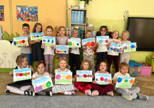 Zdjęcie dzieci z grupy 4 ze swoimi pracami plastycznymi- kropkowe gąsiennice