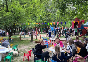 Widok na ogród oraz rodziców i dzieci podczas pikniku