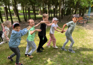Dzieci bawią się w pociąg w ogrodzie przedszkolnym