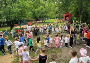 Wspólne tańce w wielkim kole w ogrodzie