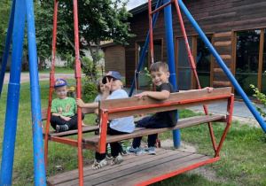 Chłopcy bujają się na dużej ogrodowej huśtwce