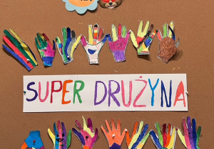 Prace plastyczne grupy czwartej- kolorowy napis Super drużyna, dookoła kolorowe dłonie