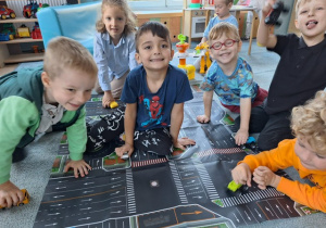 Chłopcy bawią się razem na macie z rysunkiem ulicy