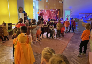 Dzieci ustawione w wężu przechodzą pod zwisającą liną