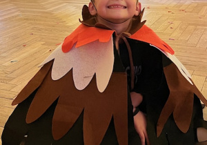 Uśmiechnięty chłopiec z grupy 3 siedzi na podłodze w stroju jeża