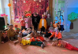 Zdjęcie grupowe grupy 3 na tle dużego zdjęcia z jesiennym krajobrazem