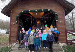 Dzieci z grupy 3 stoja na tle Szopki Bożonarodzeniowej