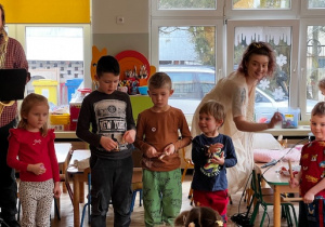 Dzieci grają na instrumentach razem z panem, który gra na saksofonie