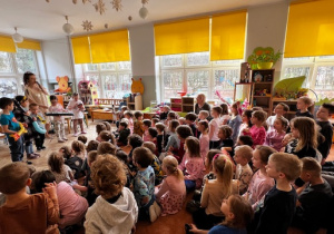 Dzieci grają na instrumentach, prowadząca śpiewa piosenkę