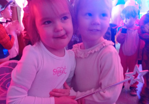 dwie dziewczynki z grupy pierwszej w strojach wróżek przytulają się