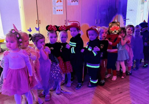 Dzieci z grupy 1 stoją ustawione w pociąg