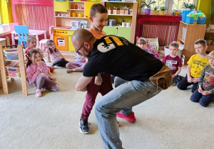 Chłopiec z grupy 5 ćwiczy odpowiednie chwyty z panem Markiem