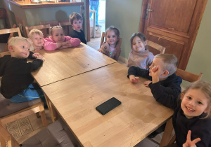 Zdjęcie grupowe dzieci z grupy 2, które siedzą przy stolikach w Baśniowej Kawiarence