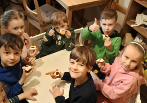 Dzieci z grupy 4 siedzą przy stoliku podczas poczęstunku