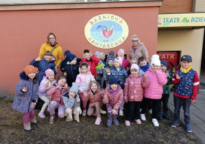 Grupowe zdjęcie dzieci z grupy 5 oraz pań nauczycielek przed wejściem do Baśniowej Kawiarenki
