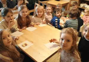 Grupa 4 siedzi przy stolikach podczas poczęstunku