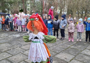 Dzieci z 2 i 3 gr stoją na tarasie na przeciwko Marzanny, śpiewają wiosenną piosenkę