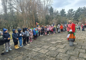 Przedszkolaki słuchają przemówienia prowadzącej i żegnają zimę wiosennymi okrzykami
