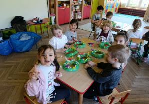 Uśmiechnięte dzieci z gr 5 ozdabiają wianki