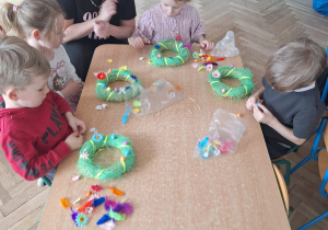 Przedszkolaki z gr 3 dekorują wianki z niewielką pomocą pani prowadzącej
