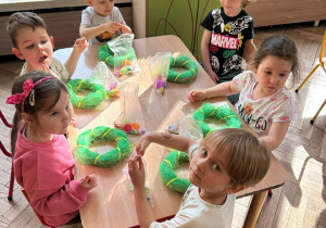 Dzieci z gr 2 rozpakowują ozdoby potrzebne do wianuszków wielkanocnych