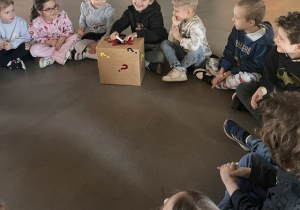 Dzieci sprawdzają co znajduje się w tajemniczym i ciemnym w środku pudełku