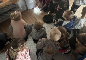 Prowadząca pokazuje jak światło załamuje się w wodzie