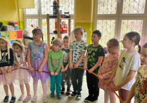 Dzieci z grupy 5 stoją w kole i trzymają linę