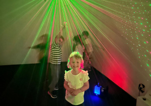 Dzieci z grupy 2 wśród zielono czerwonych laserów