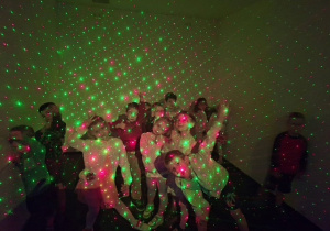 Dzieci z grupy 3 pośród kolorowych laserowych kropek