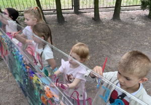Dzieci tworzące swoje malowidła na folii widziane z góry- grupa 3
