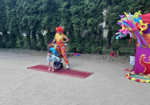 Chłopiec z 5 grupy kuca, piesek wskoczył mu na plecy