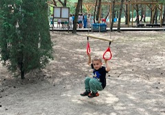 Chłopiec z 2 grupy podciąga się na obręczach
