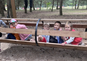 Dzieci z 3 grupy przechodzą przez drewniany otwarty tunel
