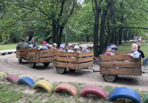 Przejażdżka dzieci z grupy 2 w drewnianych wagonikach