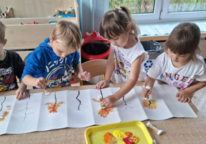 Malowanie jesiennego drzewka na kartonie przez dzieci z grupy 3