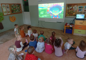 Dzieci oglądają film na tablicy multimedialnej o bohaterze kumpelkowa