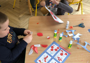 Dzieci z grupy 4 tworzące pracę plastyczną z okazji Święta Niepodległości.